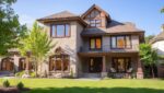A home renovation that blends traditional and modern styles, with rich exterior details and a beautifully maintained lawn.